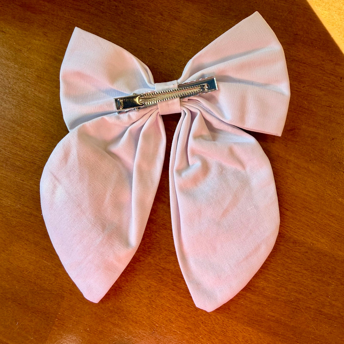 Pince à cheveux nœud en tissu blanc texturé brodé d'un petit lapin entouré de fleurs printanières