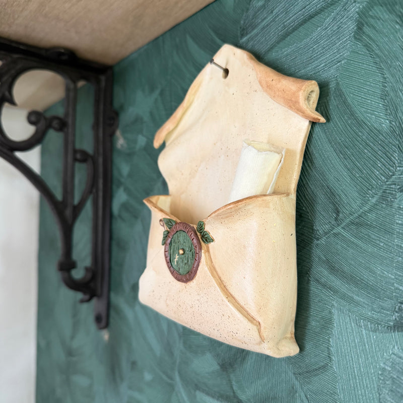 Enveloppe murale artisanale en argile effet vieux parchemin ornée d'une petite porte ronde de maison hobbit