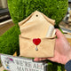 Enveloppe murale artisanale en argile effet parchemin ornée d'un cœur rouge brillant et d'une perle goutte