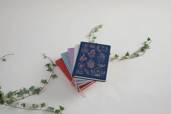 Carnet Designworks Ink à couverture en daim végétalien bleu nuit ornée de symboles mystiques dorés