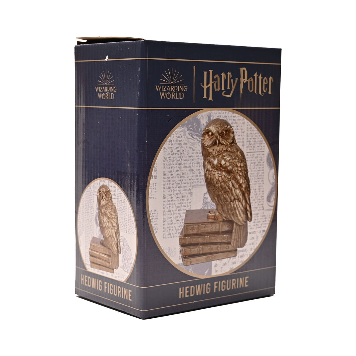 Figurine Harry Potter d'Hedwige perchée sur une pile de livres anciens, finition dorée