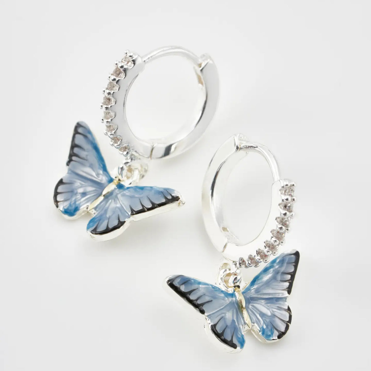 Boucles d'oreilles huggie plaqué argent Fable England, charm papillon bleu émaillé à la main