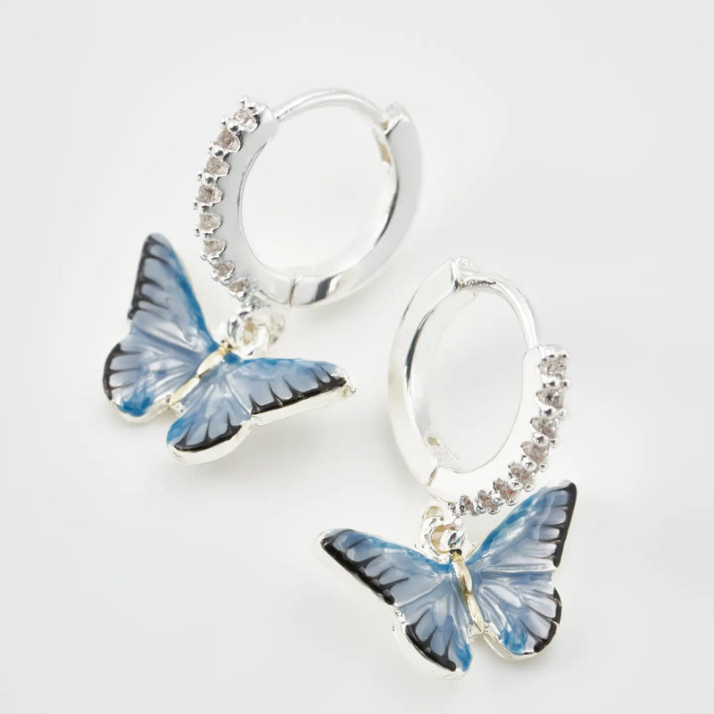 Boucles d'oreilles huggie plaqué argent Fable England, charm papillon bleu émaillé à la main