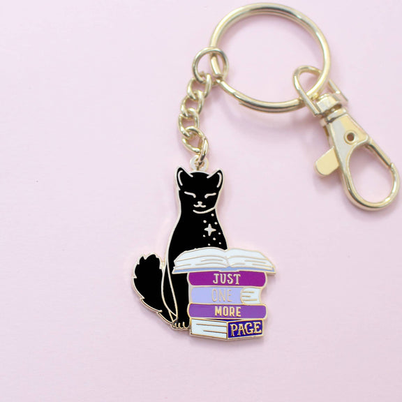 Porte-clé doré Glitter Punk chat noir perché sur une pile de romans Just one more page