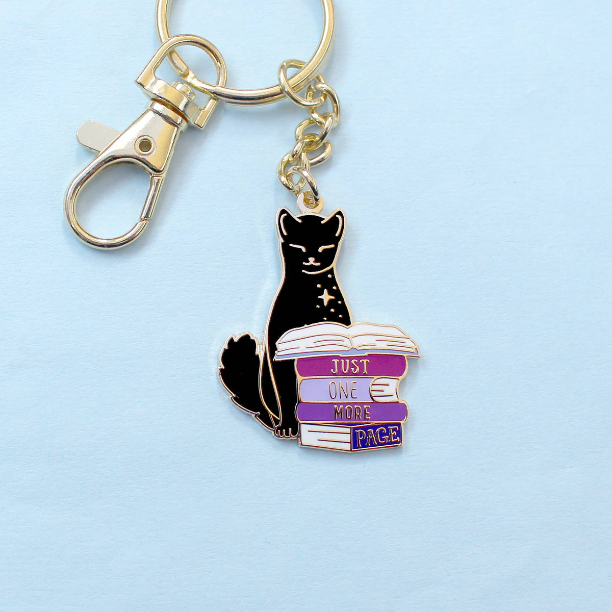 Porte-clé doré Glitter Punk chat noir perché sur une pile de romans Just one more page