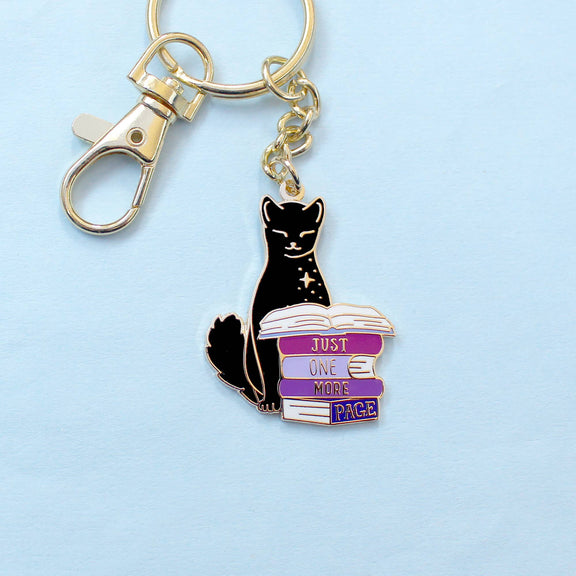 Porte-clé doré Glitter Punk chat noir perché sur une pile de romans Just one more page