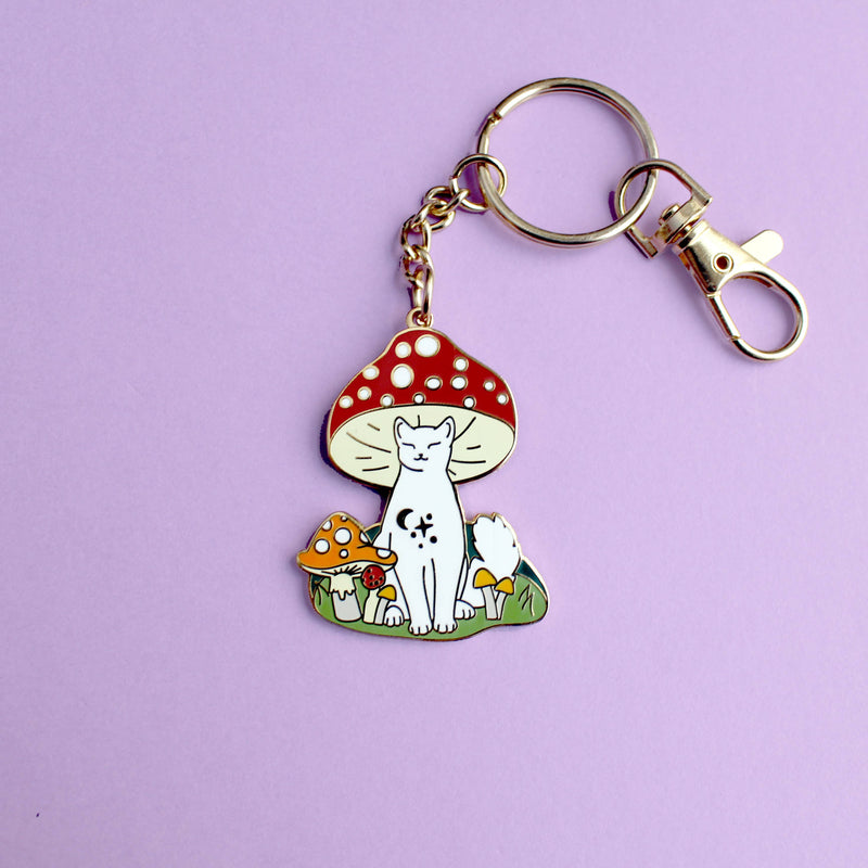 Porte-clés Glitter Punk Mushroom Cat, chat blanc assis sous un champignon rouge géant