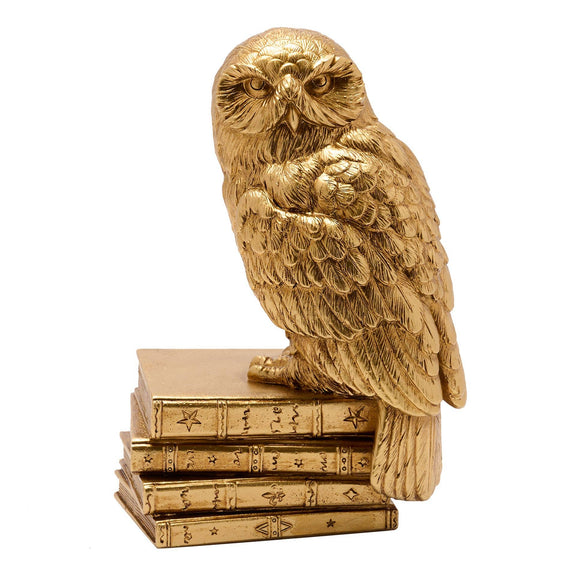 Figurine Harry Potter d'Hedwige perchée sur une pile de livres anciens, finition dorée
