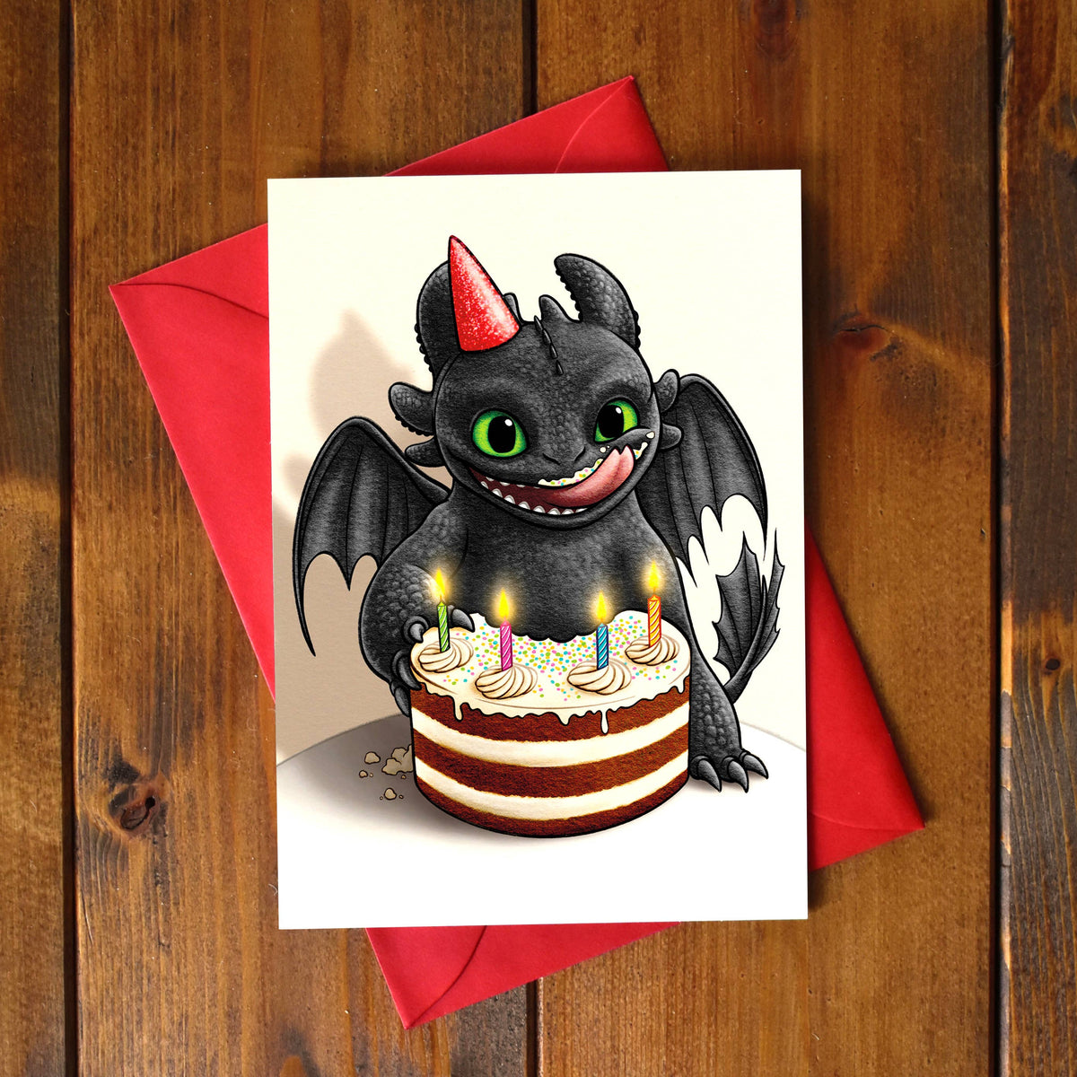 Carte d'anniversaire illustrée d'un petit dragon à chapeau de fête devant un gâteau coloré