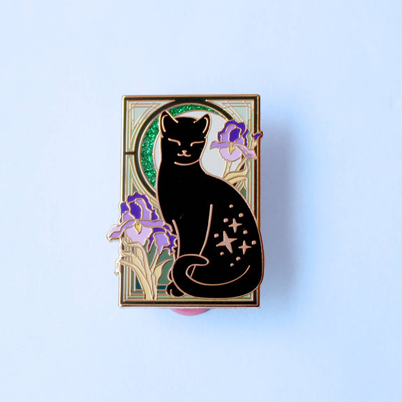 Pin's Glitter Punk Art Nouveau chat noir étoilé entouré de fleurs d'iris violettes sur fond vert