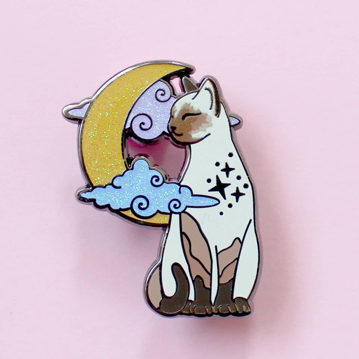 Pin's Glitter Punk chat siamois assis devant une lune scintillante et des nuages pastel