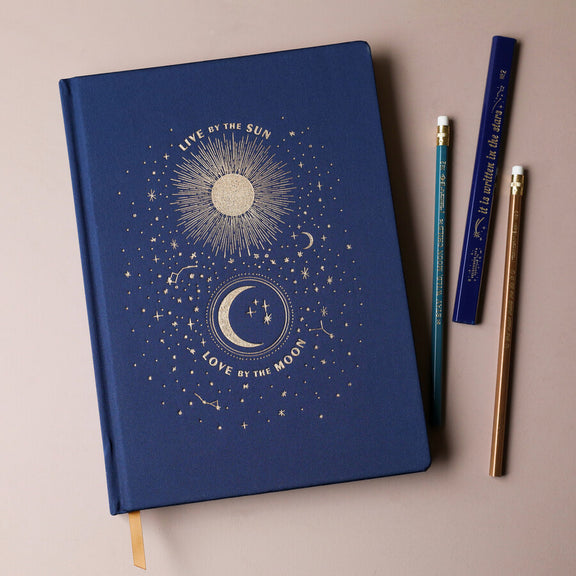 Carnet relié Live by the Sun Love by the Moon, couverture tissu bleu nuit à motifs célestes dorés