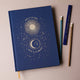 Carnet relié Live by the Sun Love by the Moon, couverture tissu bleu nuit à motifs célestes dorés