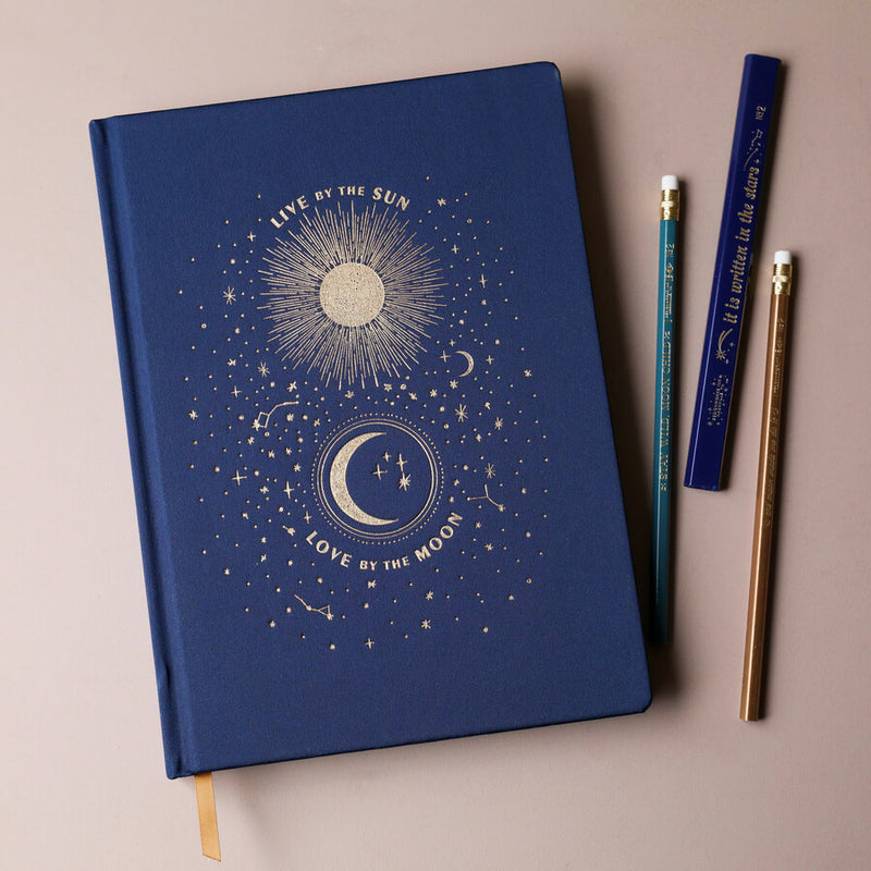 Carnet relié Live by the Sun Love by the Moon, couverture tissu bleu nuit à motifs célestes dorés