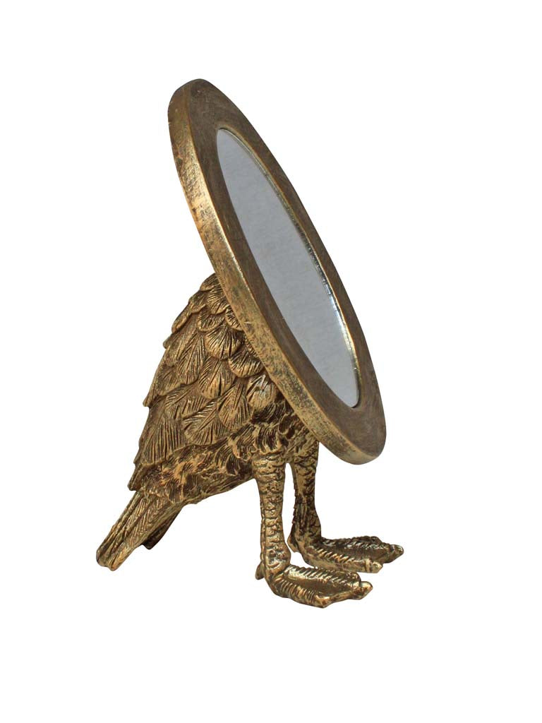 Miroir rond sur pied porté par un oiseau doré vieilli aux plumes texturées, esprit cabinet de curiosités