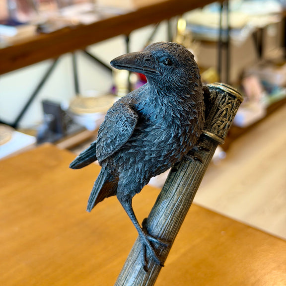 Figurine Nemesis Now d'un corbeau perché sur le marteau de Thor posé sur des rochers
