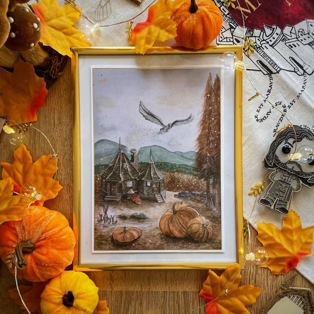 Illustration A5 d'une cabane d'automne survolée par une créature ailée, univers des sorciers