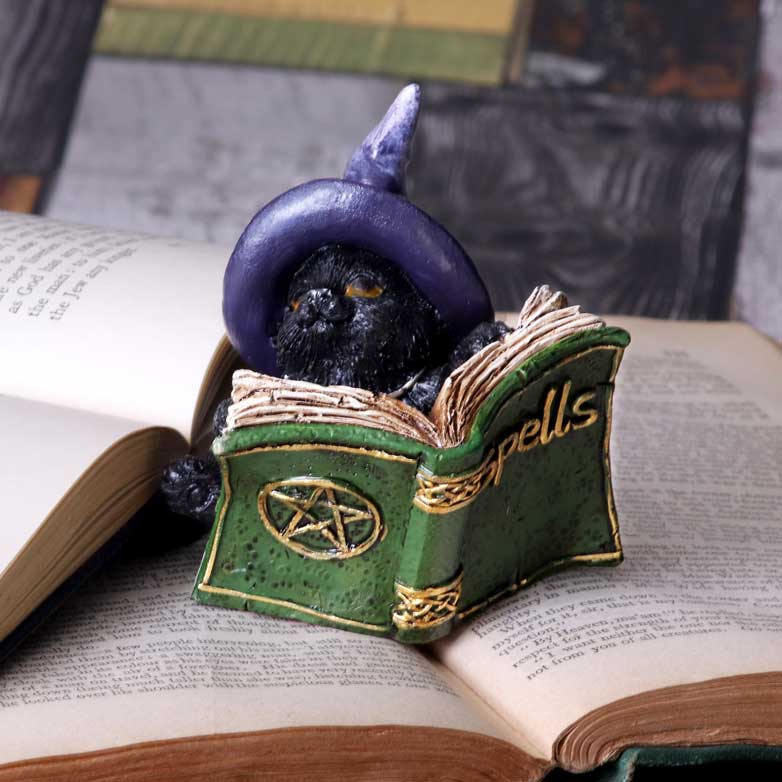 Statuette en résine d'un chat noir au chapeau de sorcier violet lisant un livre de sortilèges vert