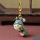 Strap bijou de sac Totoro gris tenant un sakuramochi rose enveloppé d'une feuille de cerisier
