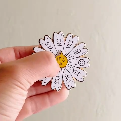 Pin's marguerite interactif Occasionalish dont le cœur tourne pour révéler oui, non ou un smiley